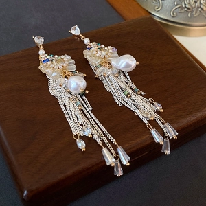 Detail of vintage bow tassel earrings with white pearls and crystals on wood