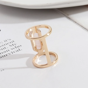 Detail of a gold double-band ring featuring a rectangular pink natural crystal stone