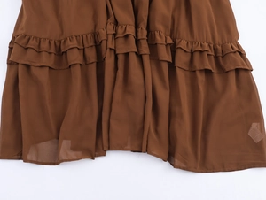 Détail de l'ourlet de robe en mousseline café avec textures de volants multicouches