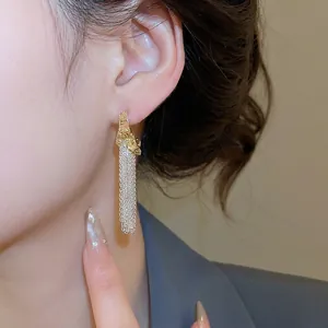 French vintage gold C-shape stud earrings with long silver tassel chain on model