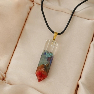 Macro detail of a hexagonal resin pendant with colorful crystals on a beige silk base
