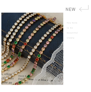 Macro detail of colorful zircon tennis bracelets on vintage books with lace