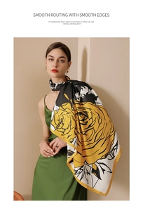 Close-up of vibrant yellow floral print on a white faux silk scarf with premium stitching