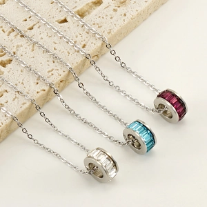 Detailed macro view of three stainless steel necklaces with colorful crystal pendants
