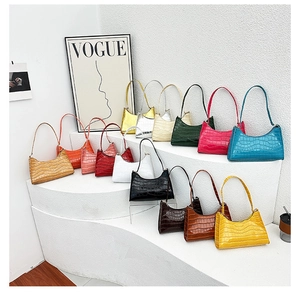 Detailed display of colorful crocodile pattern underarm bags on a white tiered stand
