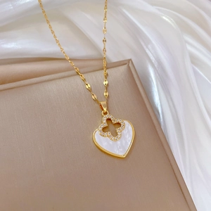 Detailed close-up of heart clover necklace with white shell inlay and sparkling crystal