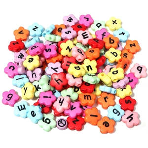 Macro view of flower-shaped acrylic letter beads in mixed colors for DIY jewelry crafts