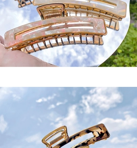 Detailed macro view of large marble and tortoiseshell acetate hair claws with gold edges