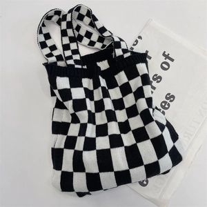 Flat lay of black and white checkered knit tote bag with soft texture and wide handle