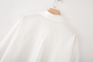 Detailed back view of white cotton poplin shirt featuring a box pleat and yoke design