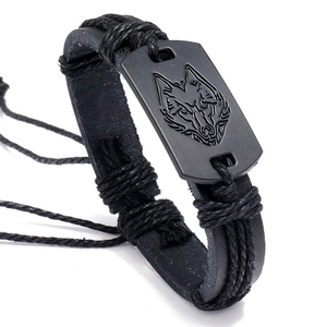 Detail of hand-woven black PU leather bracelet with wolf head engraved on black metal plate