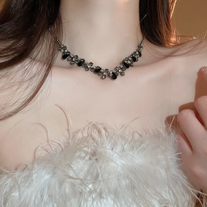 Close-up of sparkling waterdrop pendant with black gemstone and silver base on model