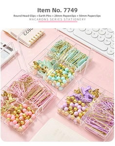 Macro shot of macaron office set with binder clips and paperclips in a clear box