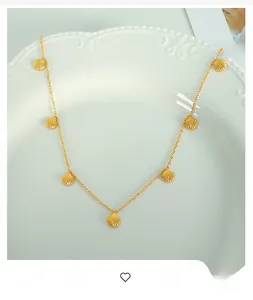 Close-up of elegant gold scalloped shell pendants on a delicate link chain necklace