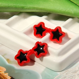 Star-shaped red doll sunglasses with black lenses displayed on a white grid background
