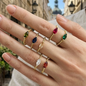 Detailed view of seven 18K gold plated beaded rings with multi-colored marquise cut crystals