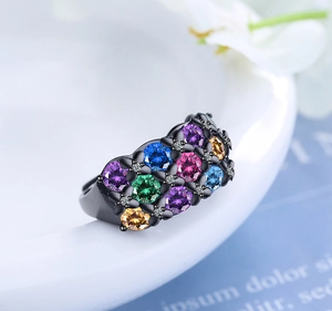 Close-up of black ring featuring vibrant multi-color gemstones and white cubic zirconia