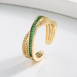 Close-up of golden ring featuring emerald green zircon and pavé white crystals