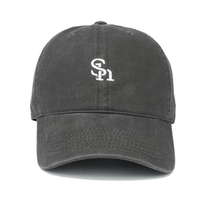 Macro view of white SI letter embroidery on dark grey washed cotton baseball cap