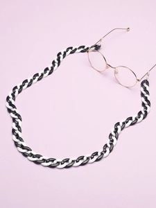 Retro black and white acrylic eyewear chain shown with rose gold glasses on purple background