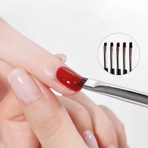 Macro detail of a flat nail brush applying deep red gel polish to a fingernail