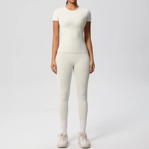 Detailed front view of women's ivory high-waisted yoga pants and matching short sleeve tee