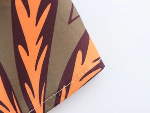 Macro shot of palm leaf print fabric and neat stitching on casual beach set