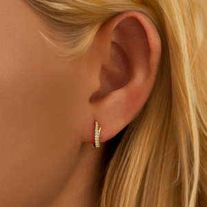 Close-up of gold s925 sterling silver huggie hoop earring with pavé diamonds on model