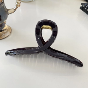 Detail view of large tortoiseshell resin hair claw clip with strong gold metal spring