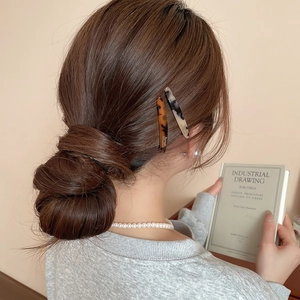 Dettaglio di fermagli in acrilico tartarugato e marmo per un look in stile francese
