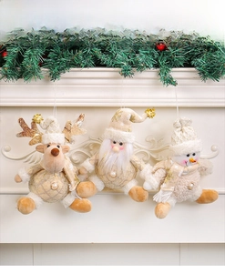 Detailed view of plush reindeer, Santa, and snowman ornaments with sequins on a fireplace