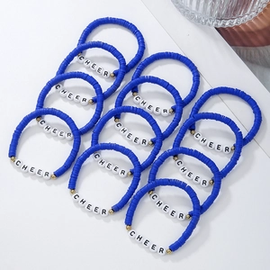 Detail of multi-layered navy blue Heishi clay bead bracelets with gold accents and CHEER letters