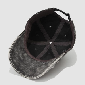 Macro detail of inner seams and brown reinforcement tape on washed denim baseball cap