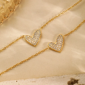 Close-up of gold-plated heart pendants with shimmering pavé cubic zirconia on o-chain