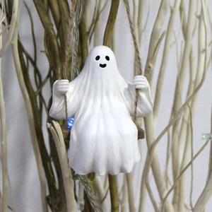 Detailed view of white ghost figurine on swing with glowing LED light and hemp rope