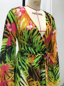 Détail du décolleté en V profond et de l'imprimé tropical sur la robe à manches