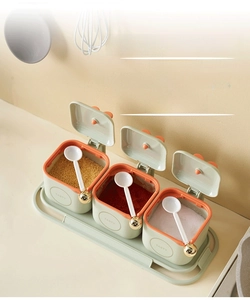 Three-grid kitchen seasoning box set with spoons and green lids for organized spice storage