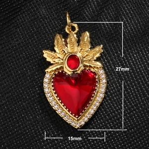 Detail view of a 27x15mm gold heart pendant with red stone and sparkling zirconia trim