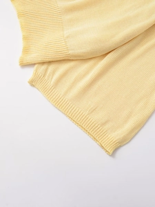 Détail de la maille jaune clair montrant le point plat fin et le bord côtelé doux