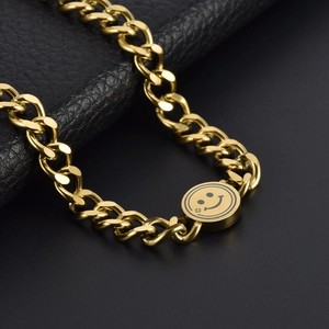 Elegant gold Cuban chain necklace featuring a round smiley face pendant on a leather base