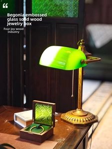 Detail of walnut wood jewelry box with green embossed glass lid and velvet interior