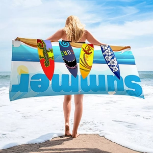 Detail of soft quick-dry beach towel with vibrant surf pattern and ocean theme design