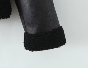 Close-up of faux suede jacket cuff with black faux shearling lining and stitching