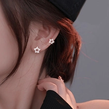 Detail of silver star earrings and ear cuff with zircon inlay on female model
