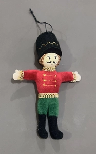 Detail of Nutcracker fabric ornament with red and green felt and gold braiding