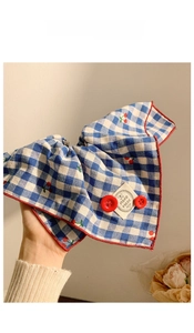 Detail of blue plaid hair scrunchie with red cherry print and handmade fabric label