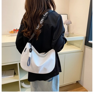 Detailed back view of a white half-moon crossbody bag with lettered webbing shoulder strap