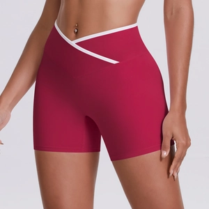 Close-up of high-waist yoga shorts featuring a deep red fabric and white V-cross waistband