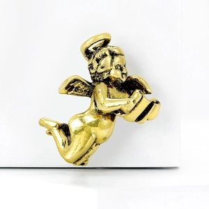 Macro detail of golden metal angel pin showing vintage texture and craftsmanship