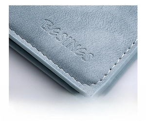 Macro shot of light blue leather texture with neat white stitching and embossed logo detail